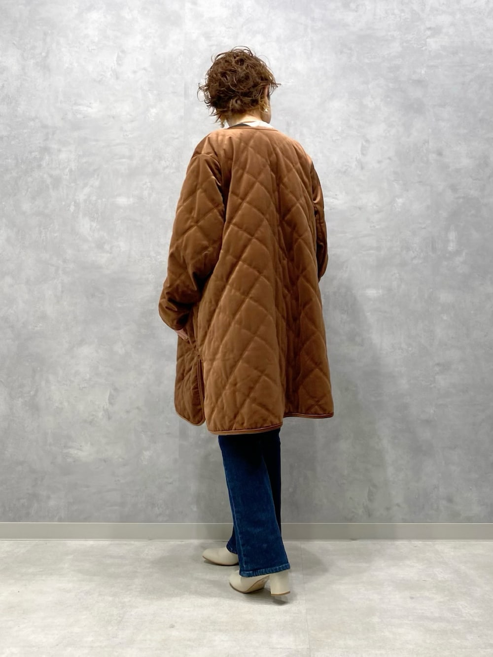 ブラウン系のブルゾン、ブルー系のサロペット/オーバーオール、ホワイト系のブーツを着用したレディースの秋コーディネートの4枚目の写真