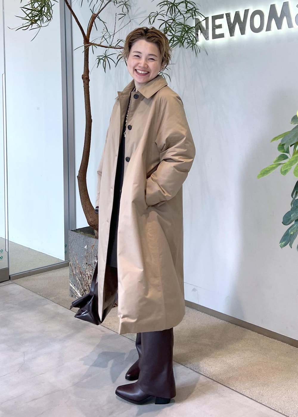 ブラウン系のブーツ、ブラウン系のショルダーバッグ、ベージュ系のダウンジャケット/コートを着用したレディースの秋コーディネートの3枚目の写真