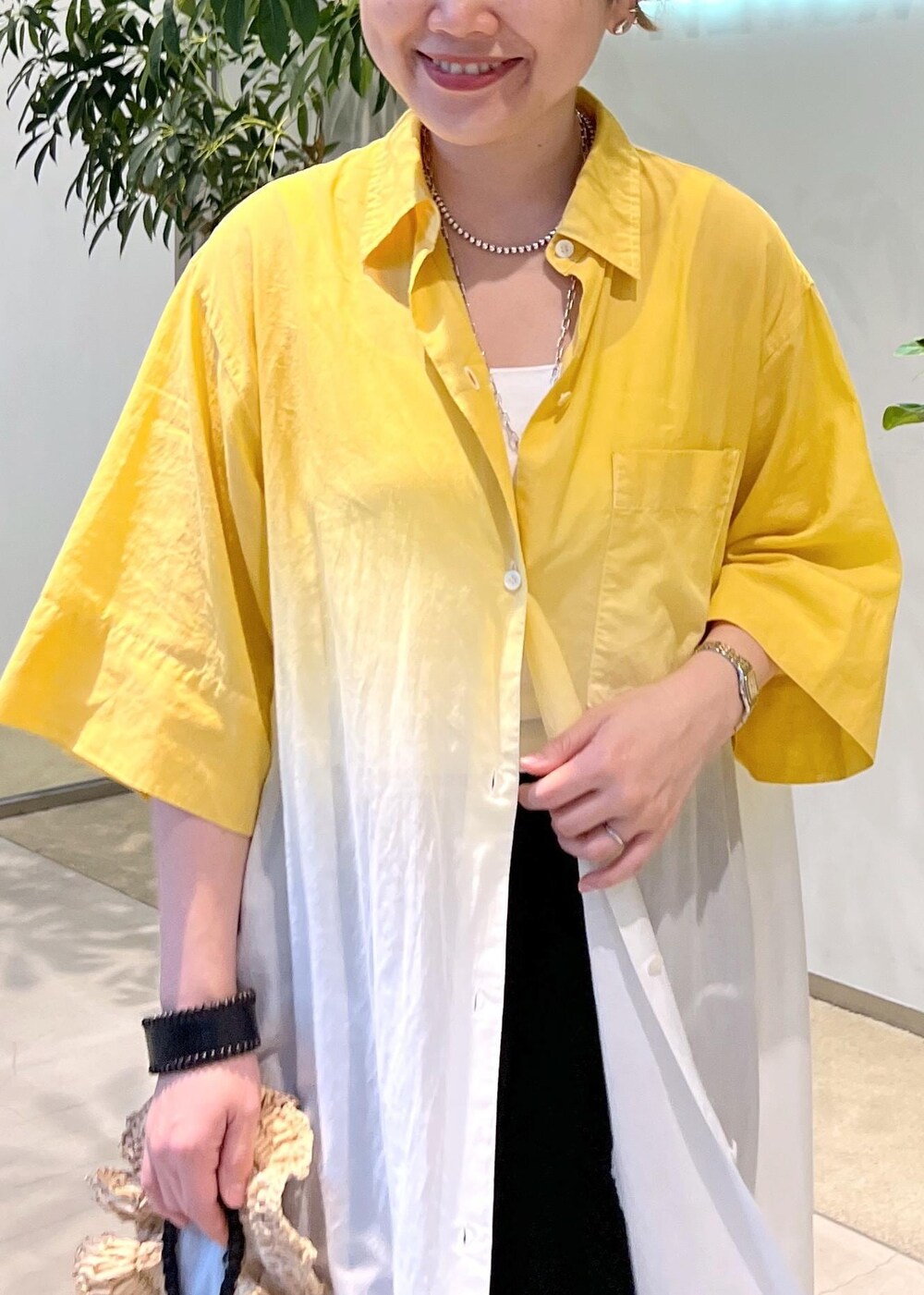 ブラック系のサンダル、ホワイト系のハンドバッグを着用したレディースの夏コーディネートの6枚目の写真