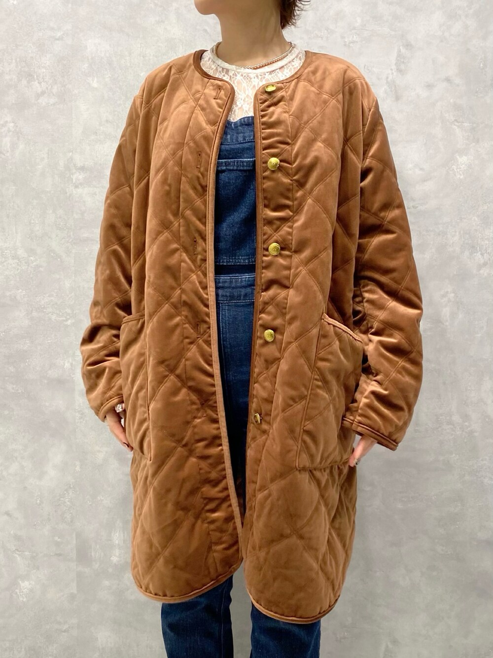 ブラウン系のブルゾン、ブルー系のサロペット/オーバーオール、ホワイト系のブーツを着用したレディースの秋コーディネートの5枚目の写真