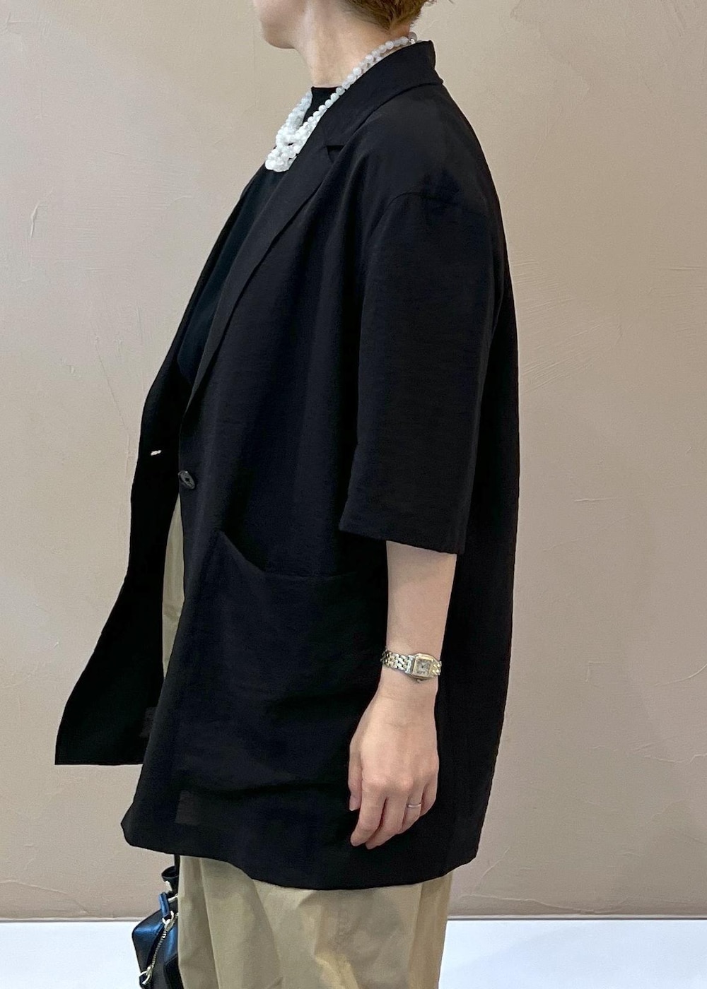 ベージュ系のその他パンツ、ブラック系のショルダーバッグ、ホワイト系のサンダルを着用したレディースの夏コーディネートの7枚目の写真