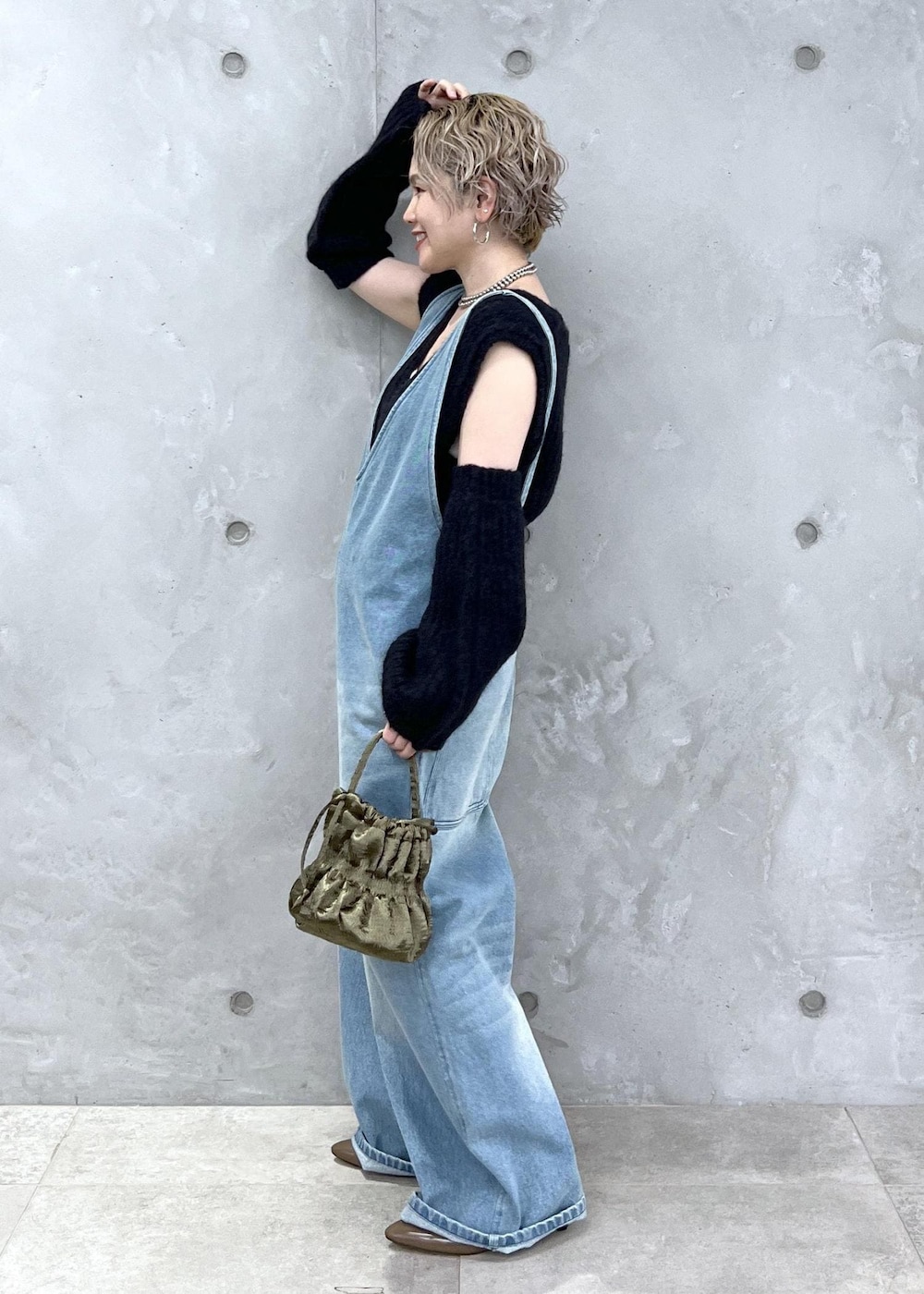 ブラック系のベスト、グリーン系のショルダーバッグ、ブルー系のサロペット/オーバーオールを着用したレディースの夏コーディネートの3枚目の写真