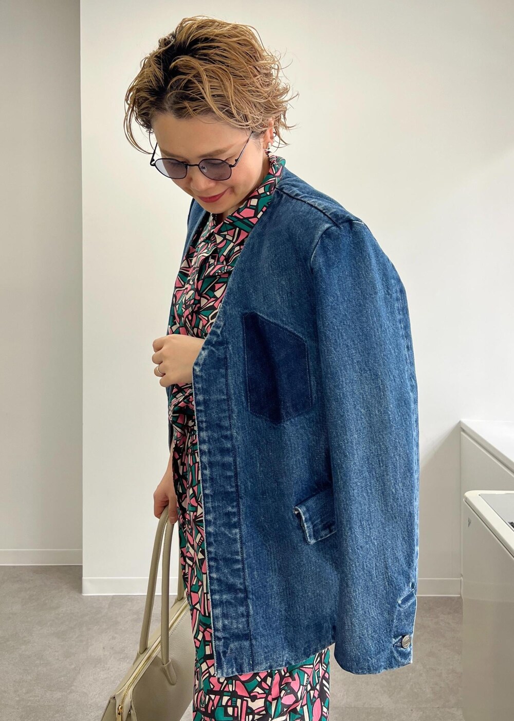 ホワイト系のボストンバッグ、グレー系のサンダル、グリーン系のつなぎ/オールインワンを着用したレディースの春コーディネートの7枚目の写真