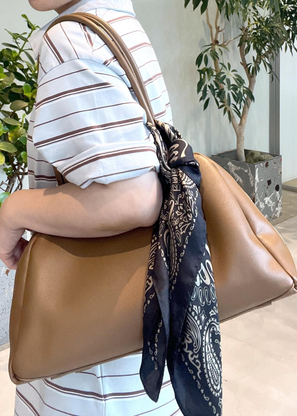 ブラウン系のボストンバッグ、ホワイト系のサンダル、ブルー系のワンピースを着用したレディースの夏コーディネートの9枚目の写真