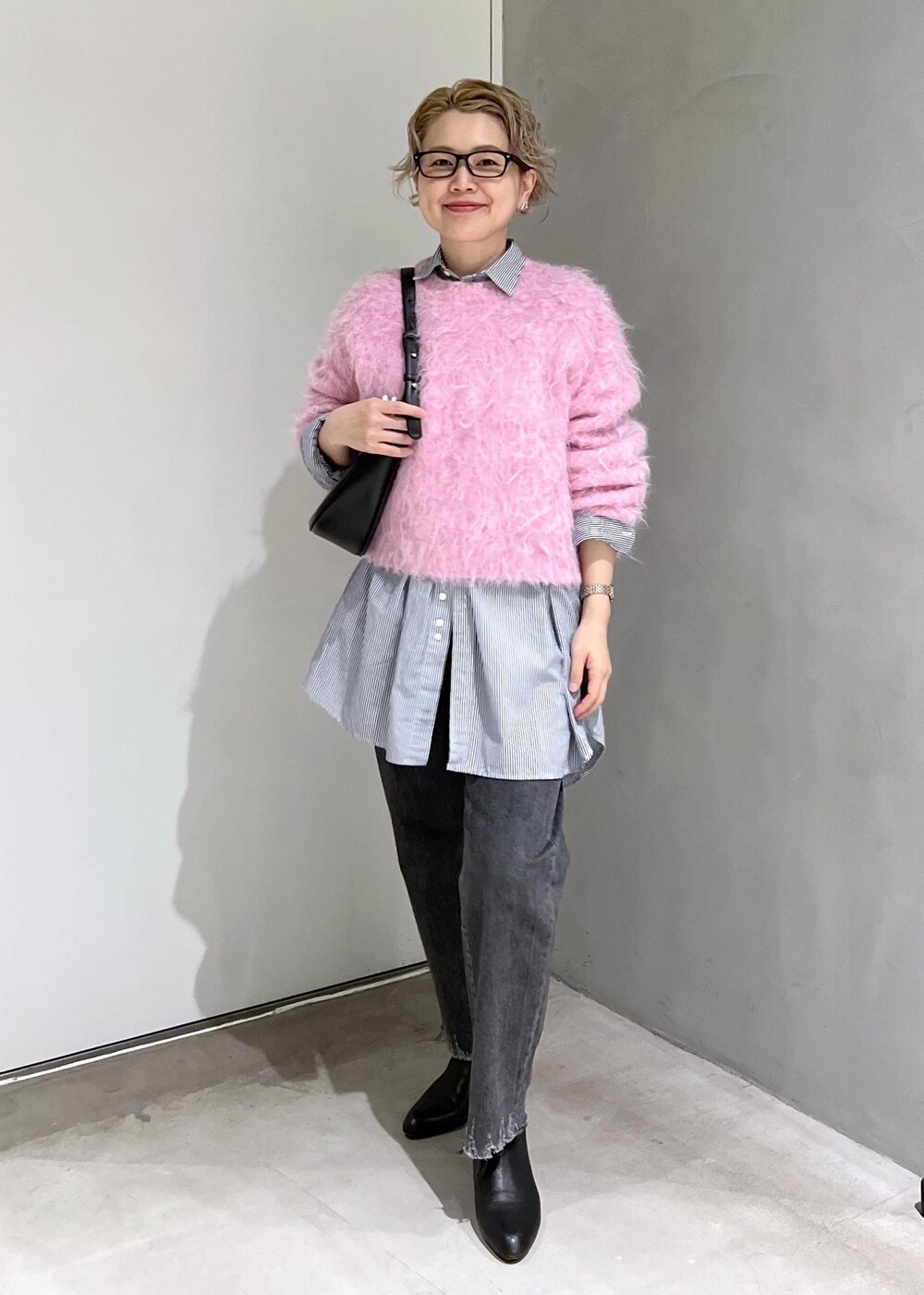 ブラック系のブーツ、ピンク系のニット/セーター、ブラック系のデニムパンツを着用したレディースの秋コーディネートの4枚目の写真