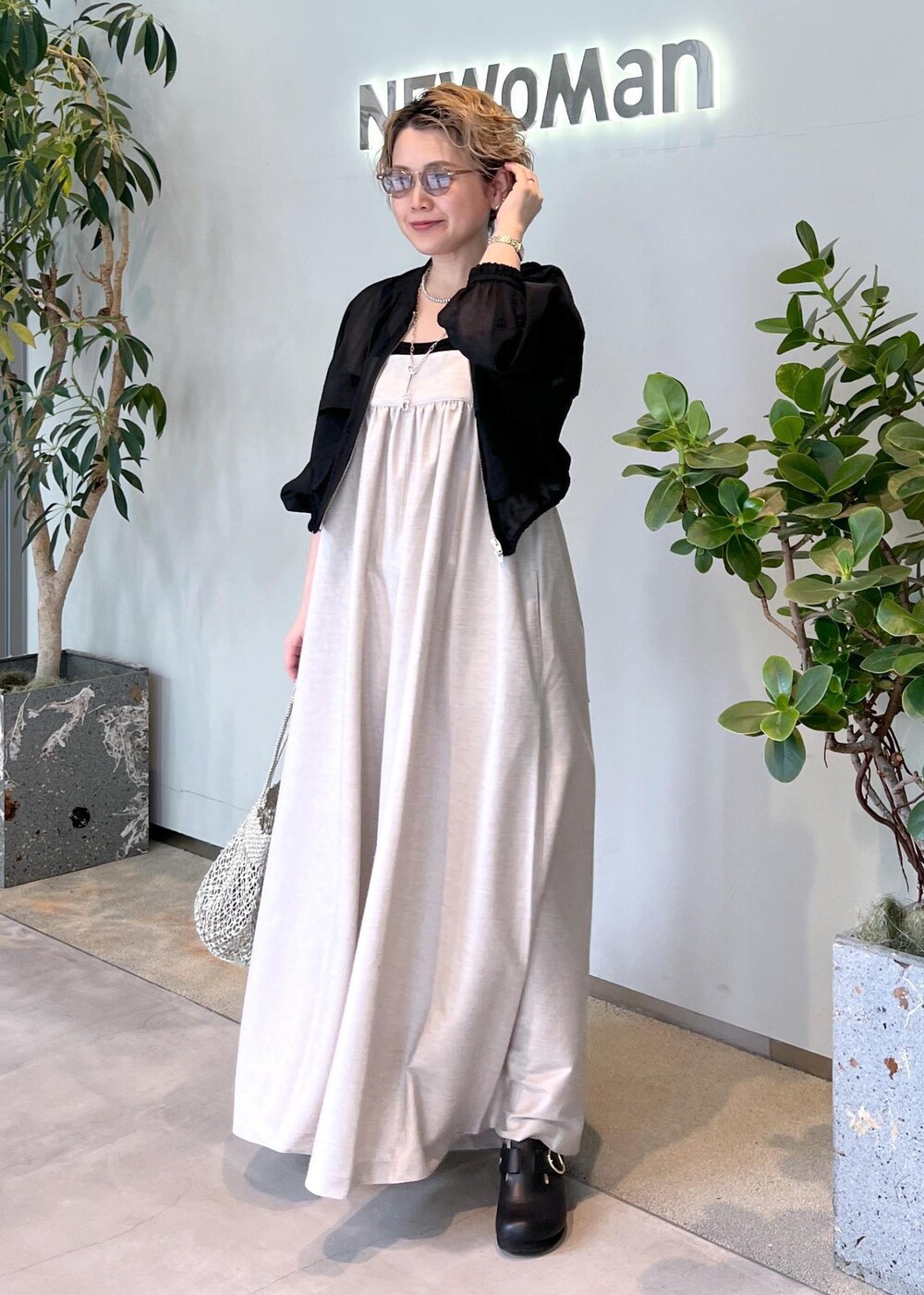 ブラック系のブルゾン、ブラック系のタンクトップ、シルバー系のトートバッグを着用したレディースの春コーディネートの5枚目の写真