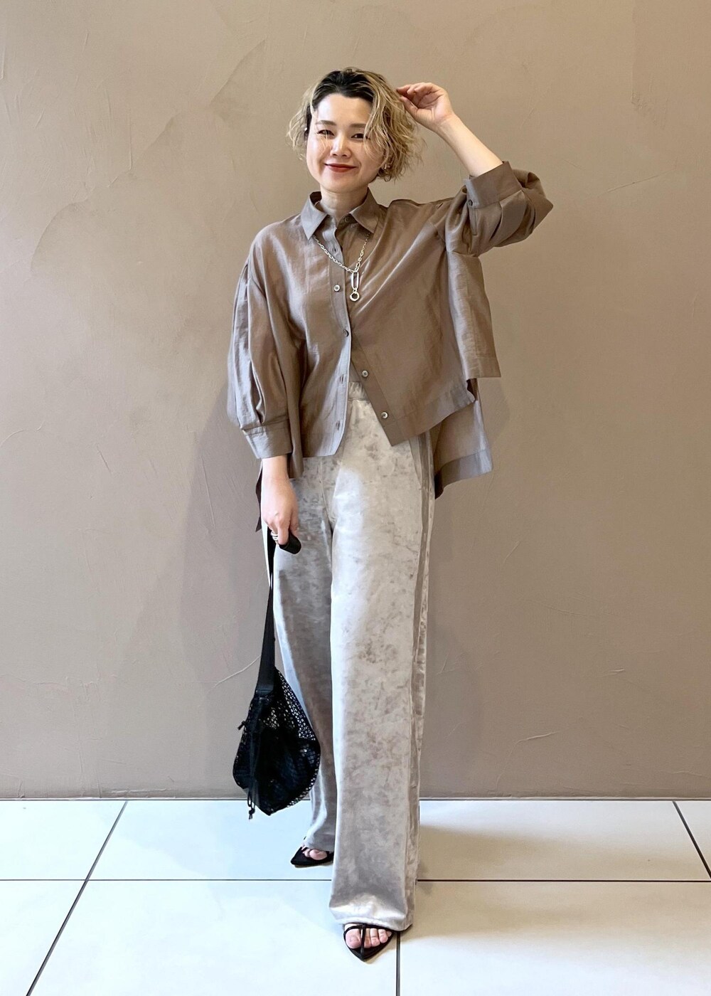 ベージュ系のその他パンツ、ブラック系のサンダル、ブラウン系のシャツ/ブラウスを着用したレディースの春コーディネートの4枚目の写真