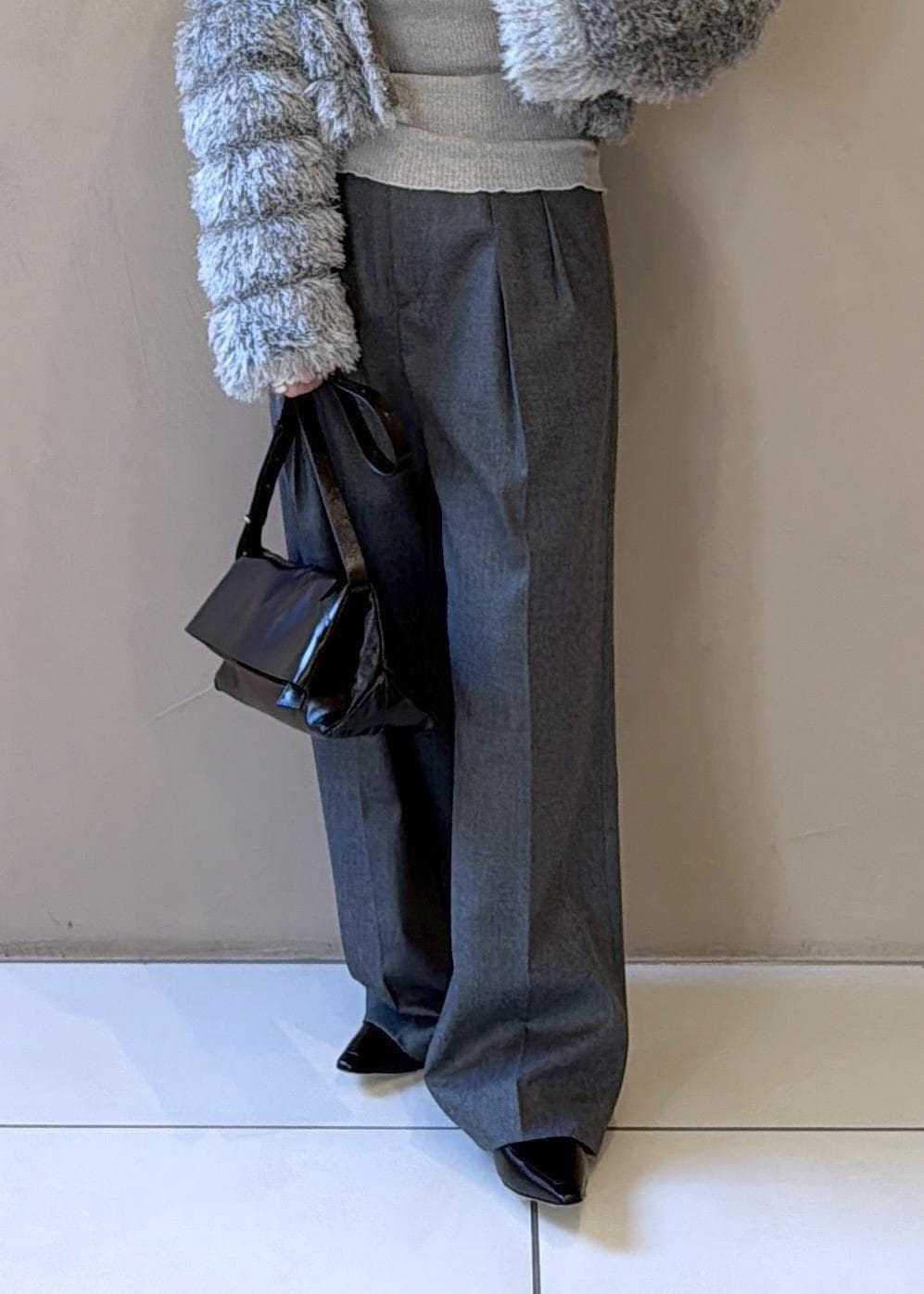 ブラック系のショルダーバッグ、グレー系のスラックス、グレー系のカーディガン/ボレロを着用したレディースの冬コーディネートの8枚目の写真