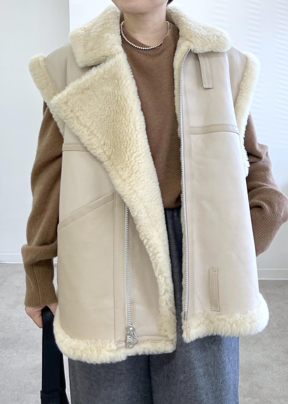 ブラック系のショルダーバッグ、グレー系のその他パンツ、ブラウン系のニット/セーターを着用したレディースの秋コーディネートの6枚目の写真