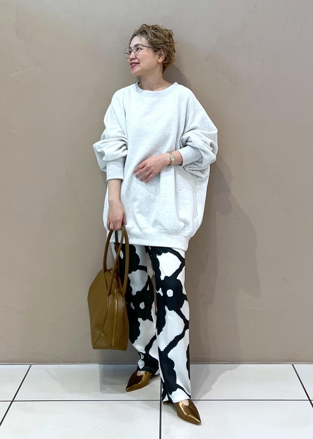 グレー系のスウェット、その他のパンプス、ブラウン系のボストンバッグを着用したレディースの春コーディネートの2枚目の写真