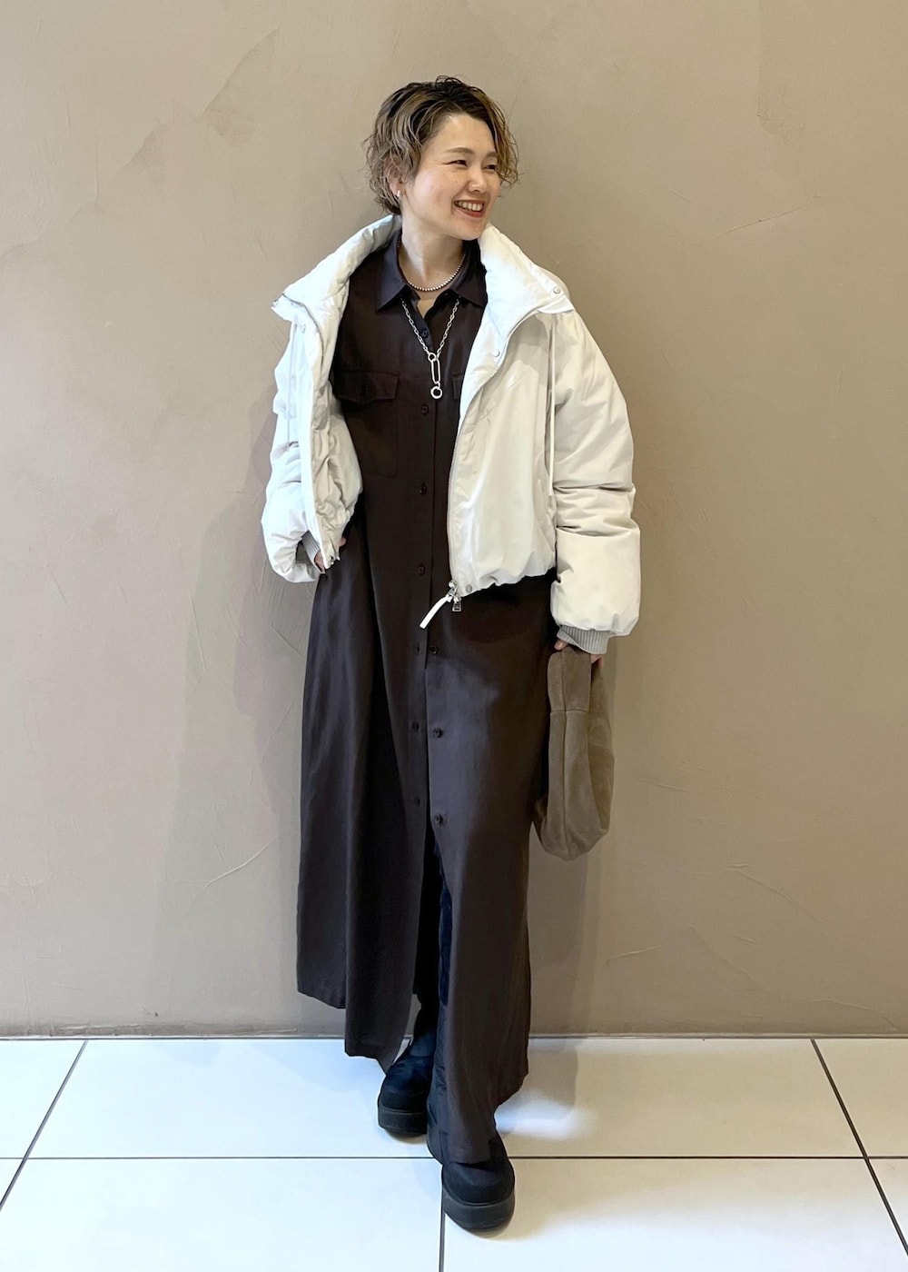 ホワイト系のダウンジャケット/コート、グレー系のハンドバッグ、グレー系のワンピースを着用したレディースの秋コーディネートの5枚目の写真