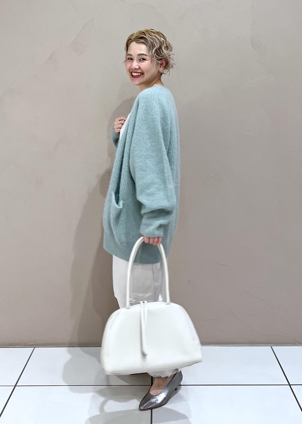 ホワイト系のTシャツ/カットソー、グリーン系のカーディガン/ボレロ、ホワイト系のカーゴパンツを着用したレディースの秋コーディネートの4枚目の写真