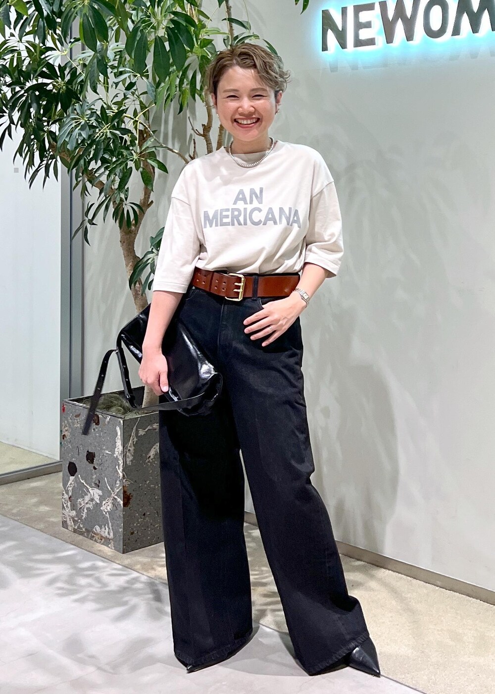 グレー系のデニムパンツ、ブラック系のショルダーバッグ、ホワイト系のTシャツ/カットソーを着用したレディースの夏コーディネートの3枚目の写真