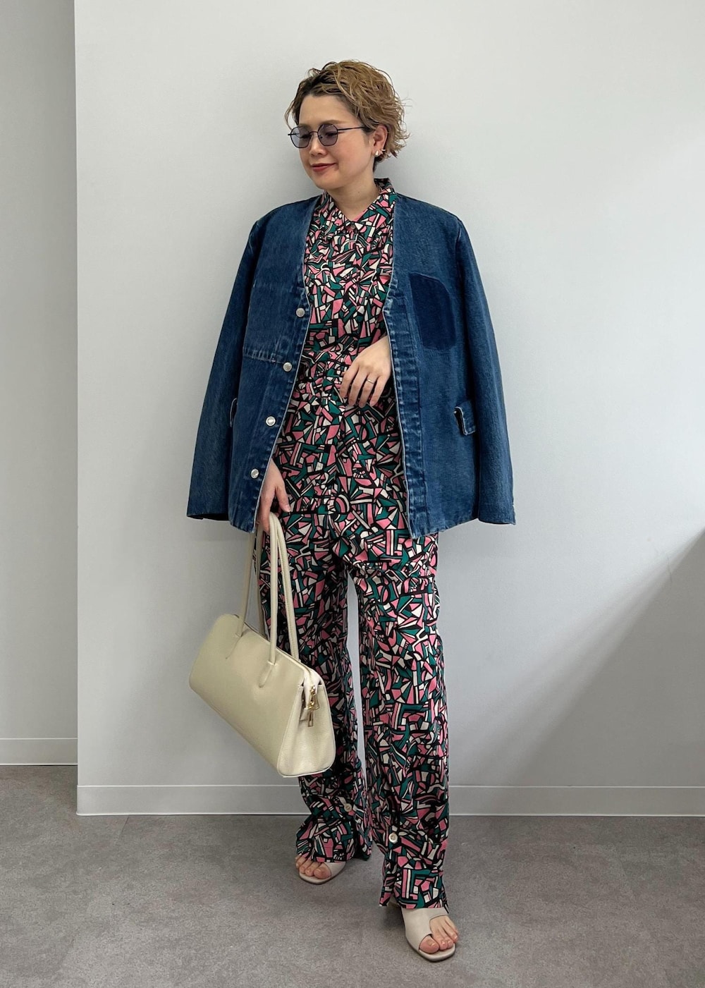 ホワイト系のボストンバッグ、グレー系のサンダル、グリーン系のつなぎ/オールインワンを着用したレディースの春コーディネートの2枚目の写真