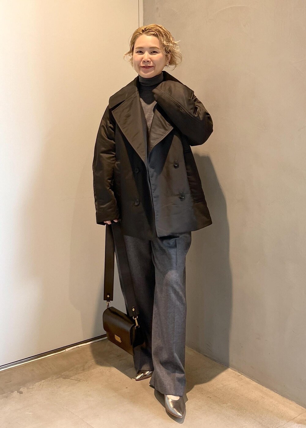 ブラック系のショルダーバッグ、グレー系のニット/セーター、グレー系のスラックスを着用したレディースの秋コーディネートの9枚目の写真