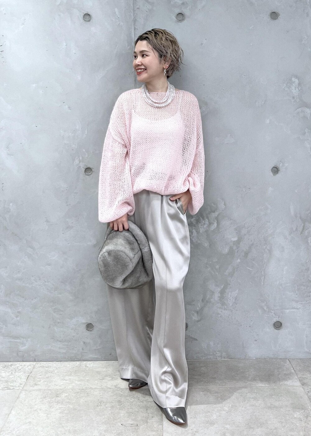 グレー系のその他パンツ、ピンク系のニット/セーター、シルバー系のパンプスを着用したレディースの夏コーディネートの4枚目の写真