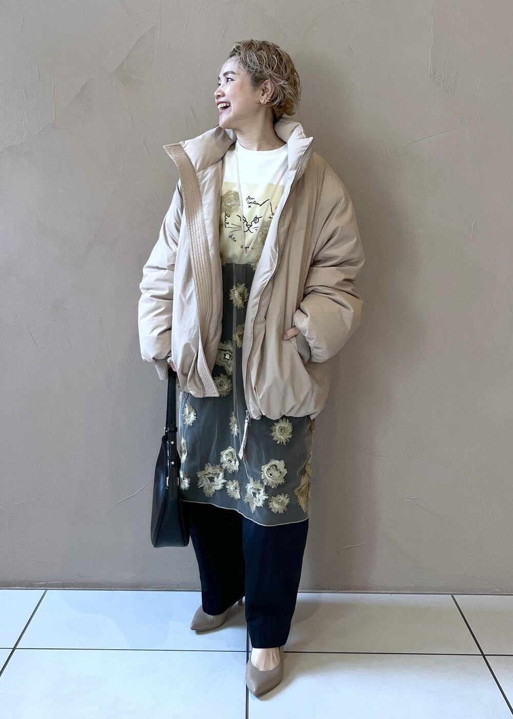 ゴールド系のワンピース、ベージュ系のダウンジャケット/コート、ホワイト系のTシャツ/カットソーを着用したレディースの秋コーディネートの4枚目の写真