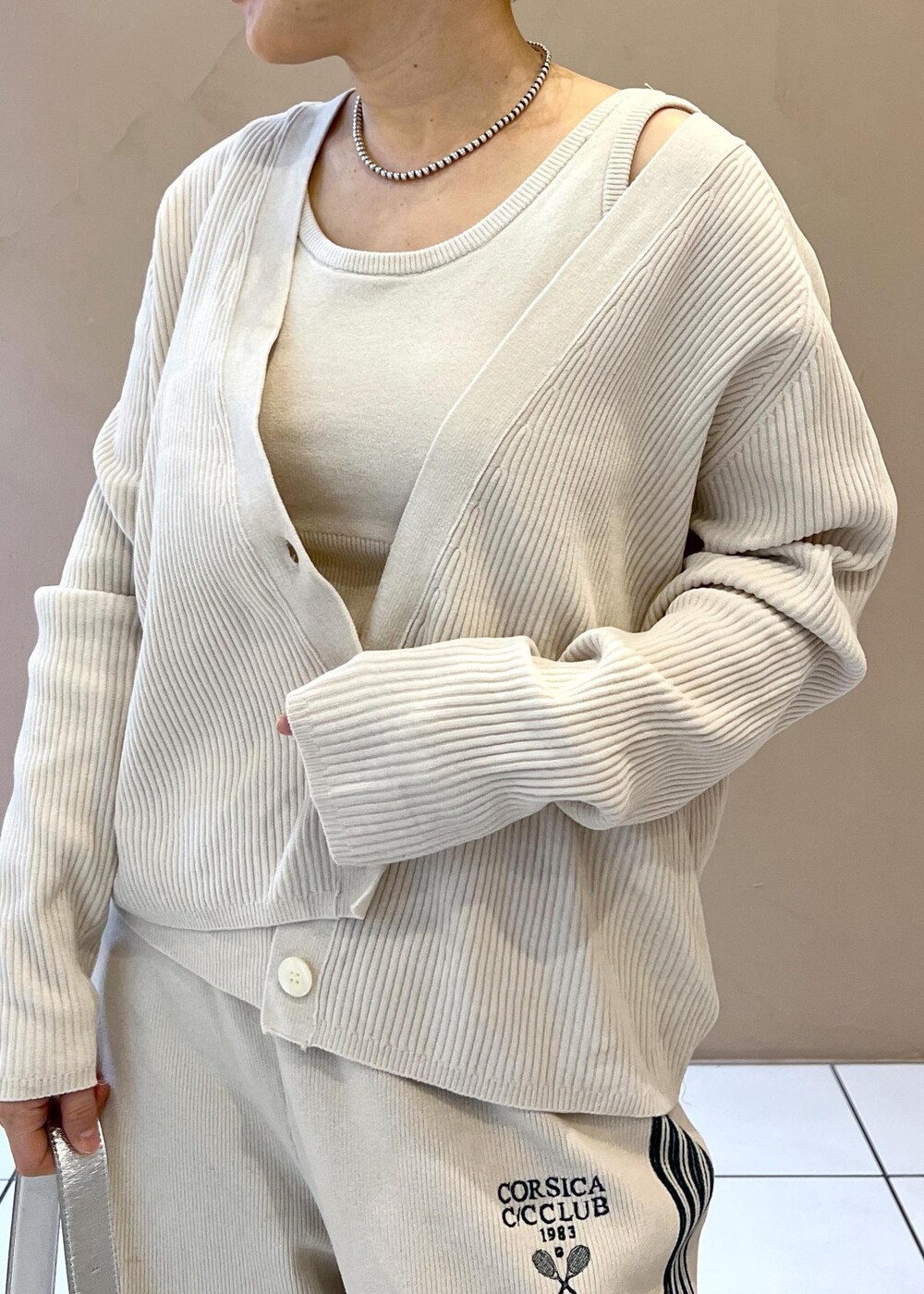 シルバー系のショルダーバッグ、ホワイト系のカーディガン/ボレロ、ホワイト系のその他パンツを着用したレディースの冬コーディネートの4枚目の写真