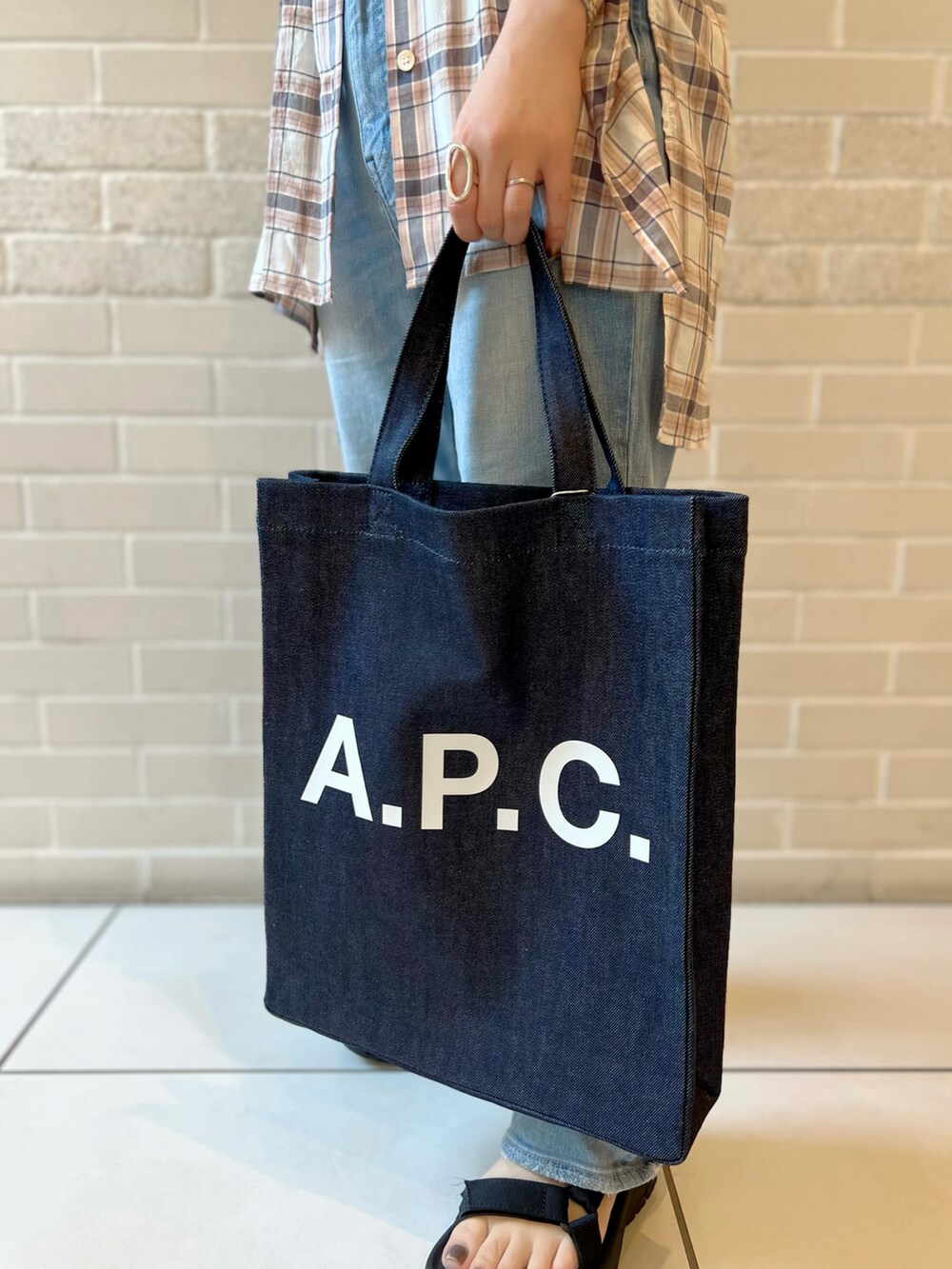 オレンジ系のシャツ/ブラウス、ブルー系のデニムパンツ、ブルー系のトートバッグを着用したレディースの夏コーディネートの5枚目の写真