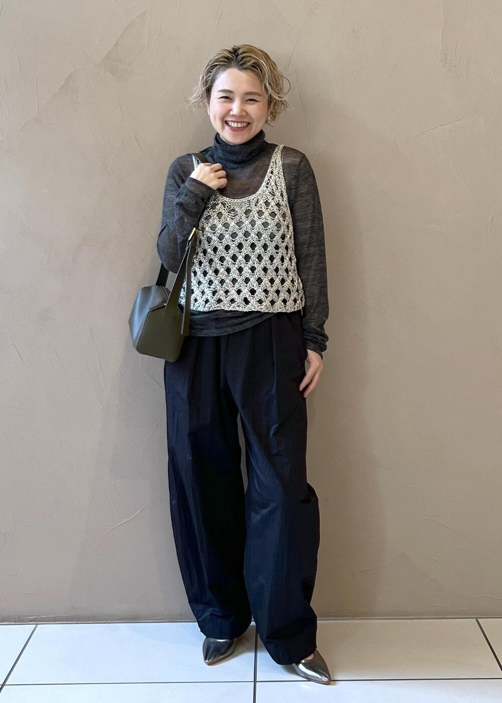 シルバー系のベスト、グレー系のブルゾン、グレー系のニット/セーターを着用したレディースの秋コーディネートの8枚目の写真