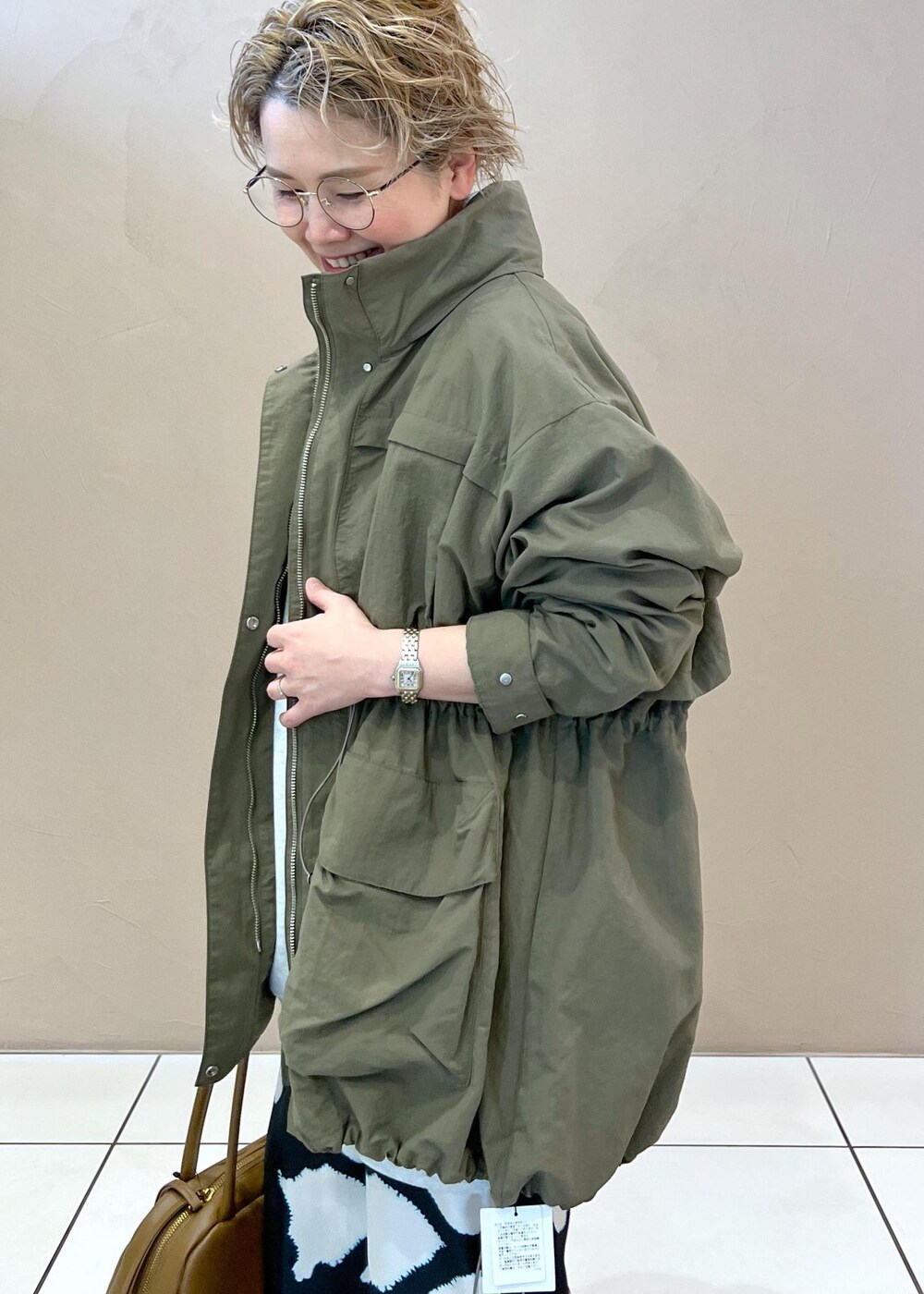 グリーン系のブルゾン、グレー系のスウェット、その他のパンプスを着用したレディースの春コーディネートの4枚目の写真