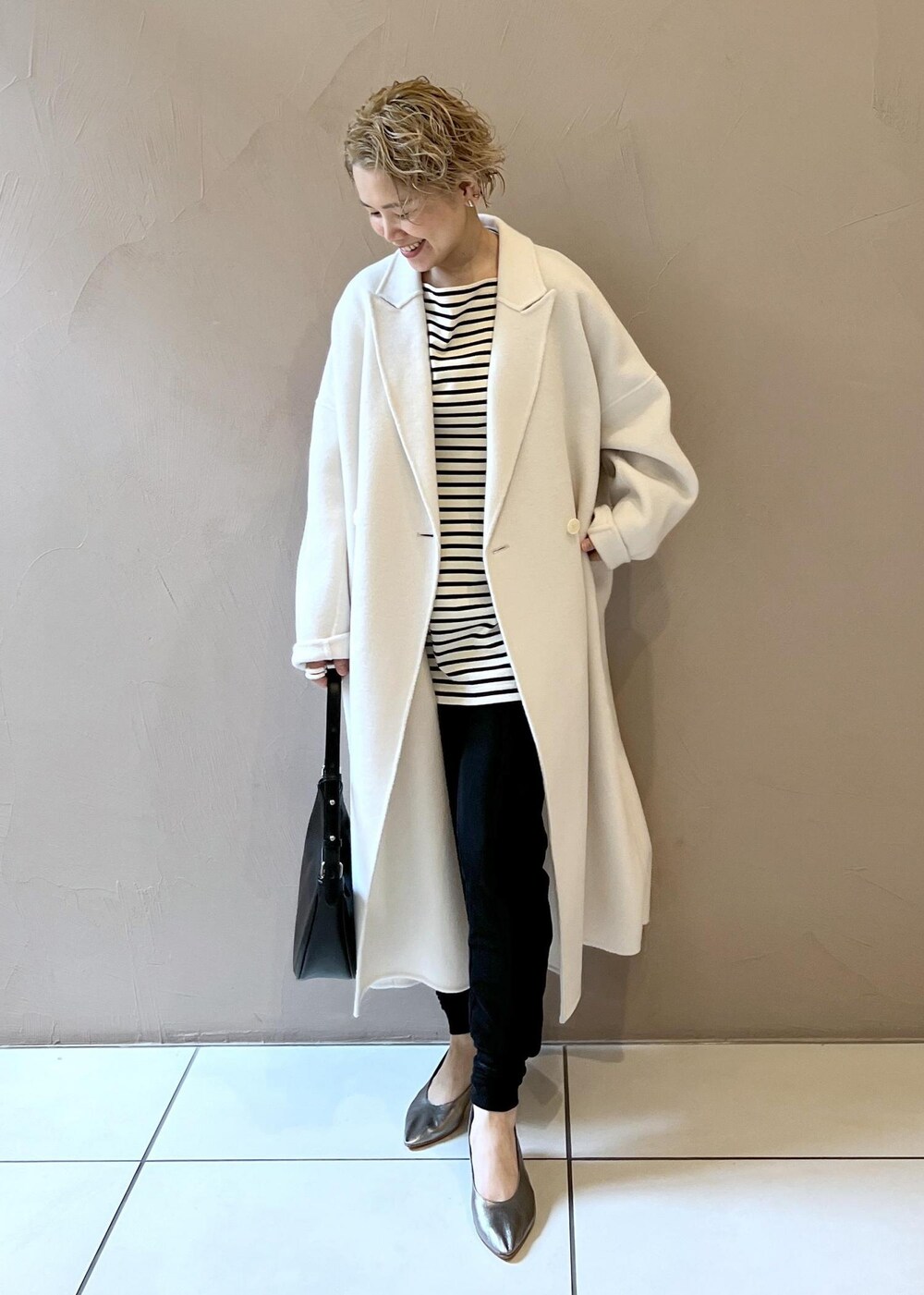 ホワイト系のその他アウター、シルバー系のパンプス、ブラック系のその他パンツを着用したレディースの秋コーディネートの2枚目の写真