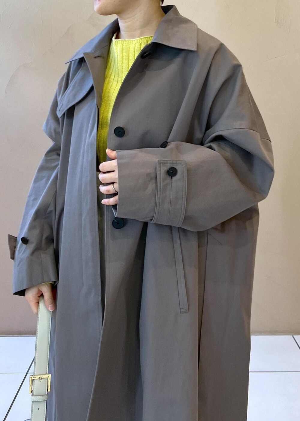 シルバー系のショルダーバッグ、イエロー系のカーディガン/ボレロ、ホワイト系のサロペット/オーバーオールを着用したレディースの冬コーディネートの8枚目の写真