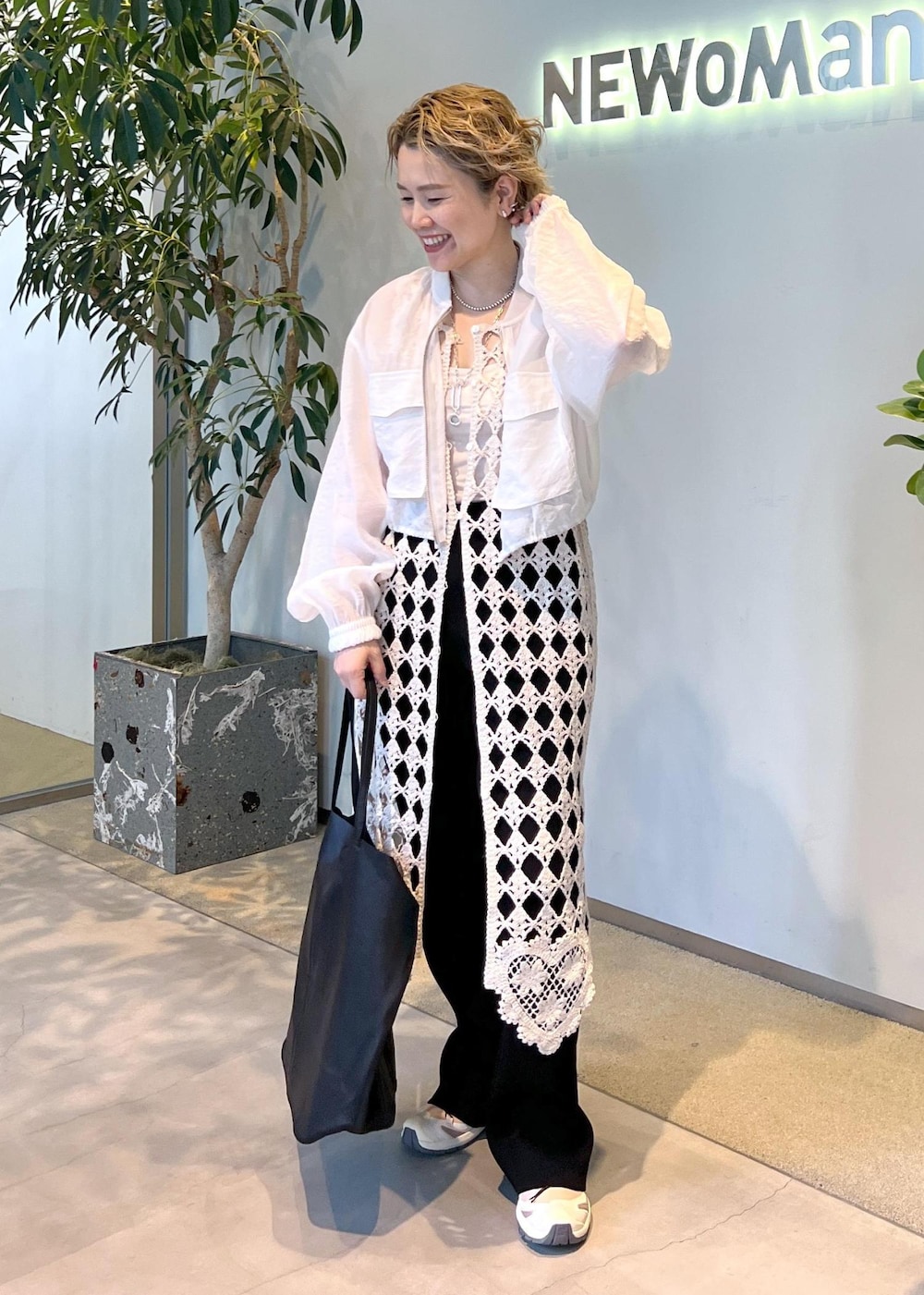 ブラック系のその他パンツ、ホワイト系のワンピース、ホワイト系のブルゾンを着用したレディースの春コーディネートの3枚目の写真