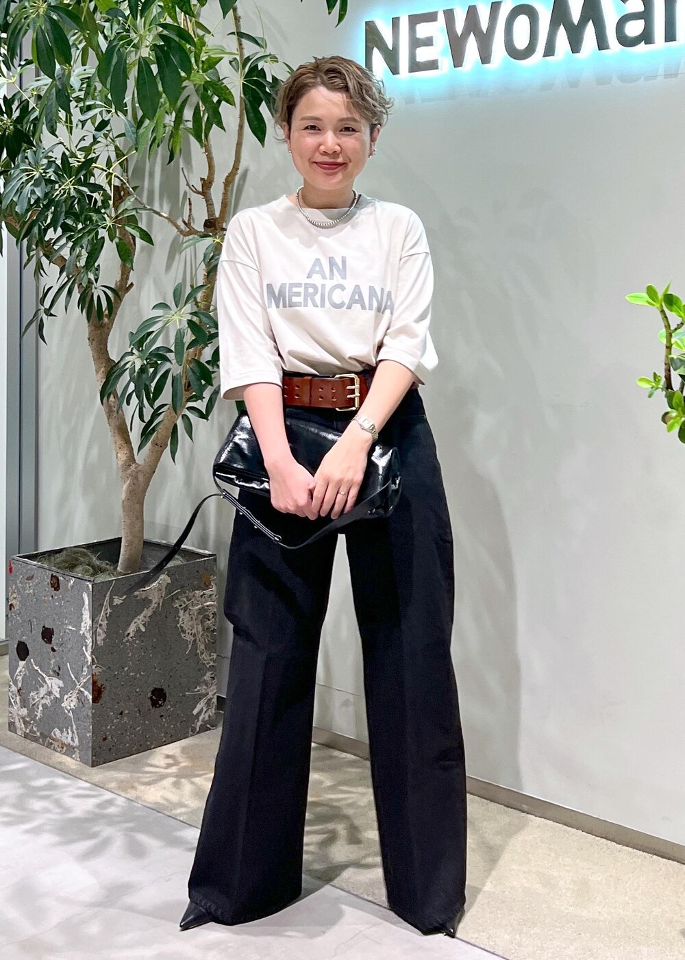 グレー系のデニムパンツ、ブラック系のショルダーバッグ、ホワイト系のTシャツ/カットソーを着用したレディースの夏コーディネートの5枚目の写真