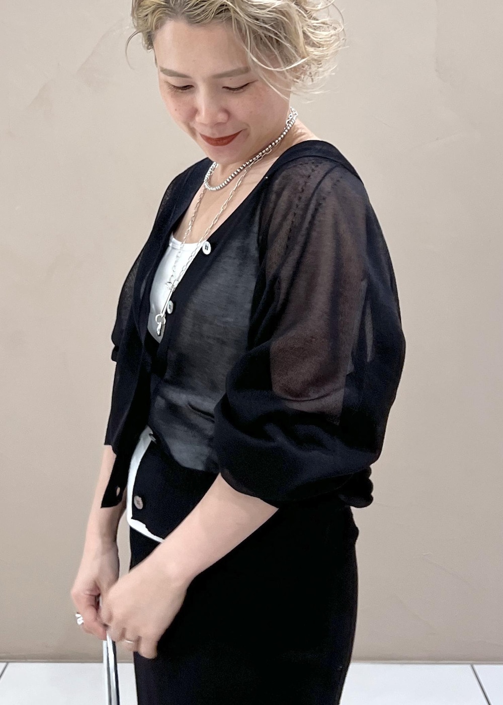 ホワイト系のタンクトップ、ブラック系のカーディガン/ボレロ、ブルー系のデニムパンツを着用したレディースの夏コーディネートの8枚目の写真