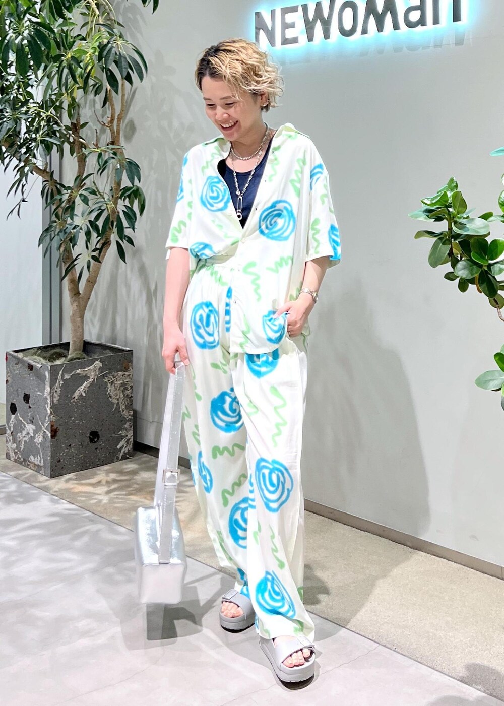 ブルー系のタンクトップ、シルバー系のショルダーバッグ、グレー系のサンダルを着用したレディースの春コーディネートの2枚目の写真