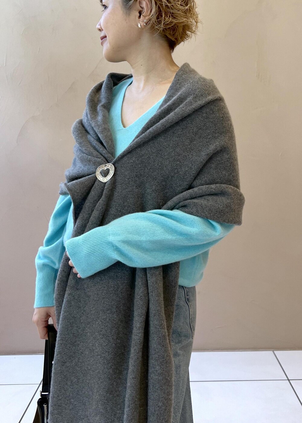 ブルー系のニット/セーター、ブルー系のデニムパンツ、ブラック系のスニーカーを着用したレディースの秋コーディネートの6枚目の写真