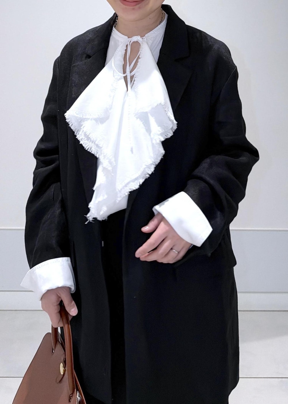 ブラック系のスカート、ブラック系のテーラードジャケット、ホワイト系のシャツ/ブラウスを着用したレディースの冬コーディネートの5枚目の写真