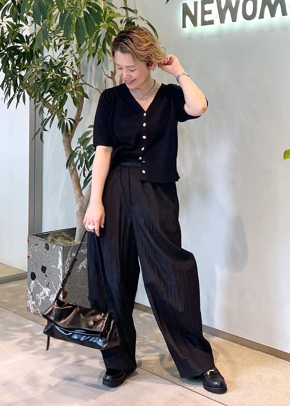 ブラック系のその他パンツ、ブラック系のローファー、ブラック系のショルダーバッグを着用したレディースの夏コーディネートの3枚目の写真