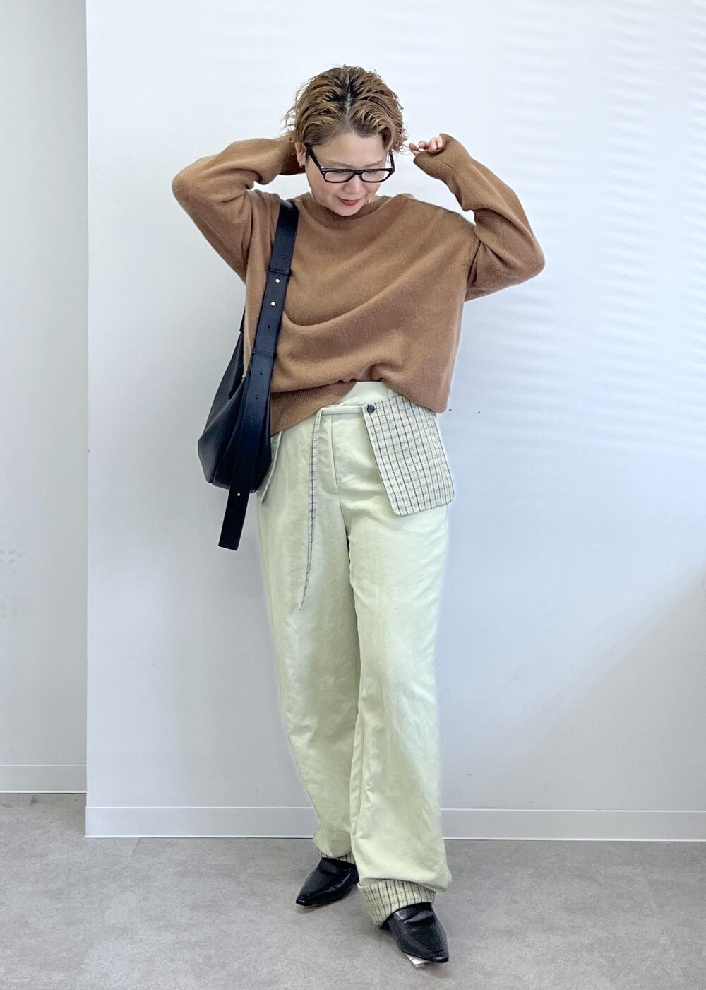 ブラック系のショルダーバッグ、ブラウン系のニット/セーターを着用したレディースの秋コーディネートの4枚目の写真