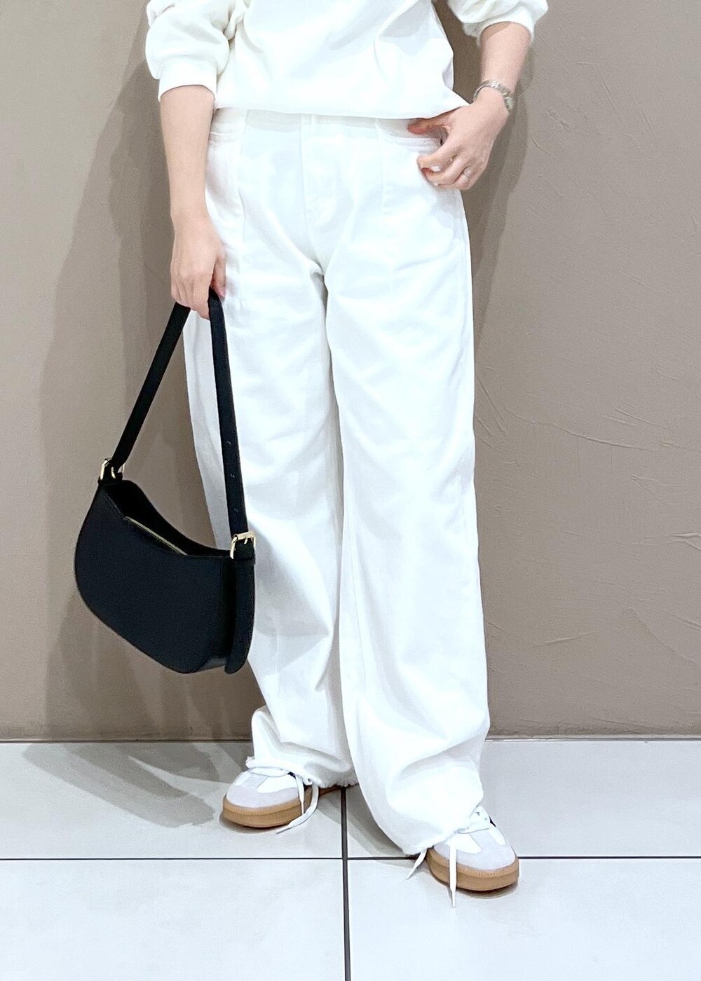 ホワイト系のデニムパンツ、ブラック系のショルダーバッグを着用したレディースの夏コーディネートの8枚目の写真