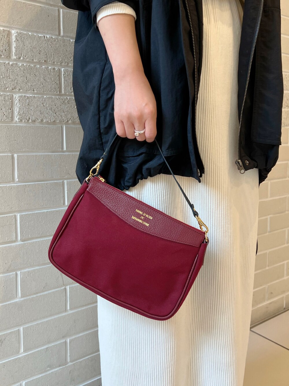 ホワイト系のTシャツ/カットソー、ブラック系のマウンテンパーカー、ホワイト系のスカートを着用したレディースの秋コーディネートの5枚目の写真