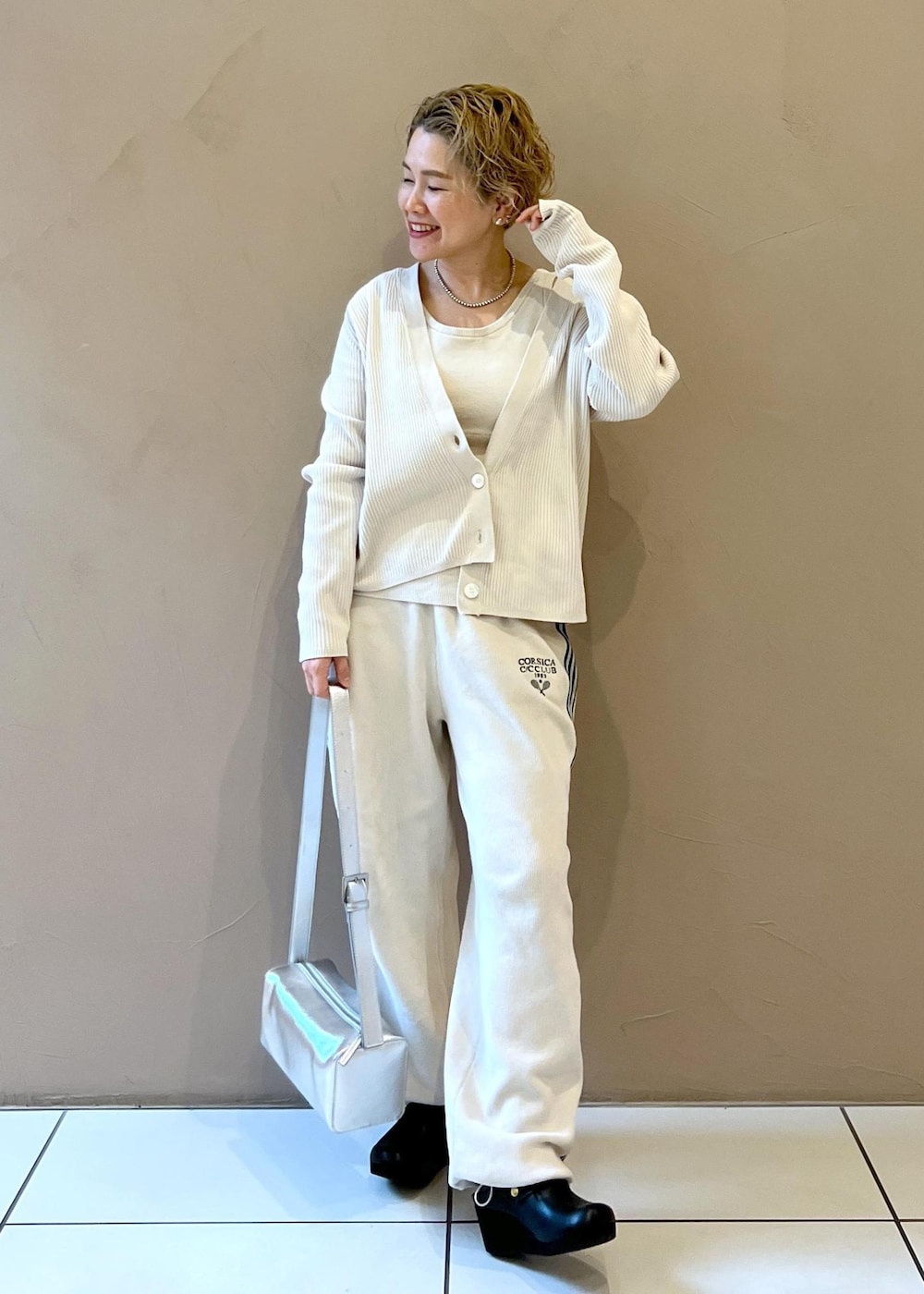 シルバー系のショルダーバッグ、ホワイト系のカーディガン/ボレロ、ホワイト系のその他パンツを着用したレディースの冬コーディネートの3枚目の写真