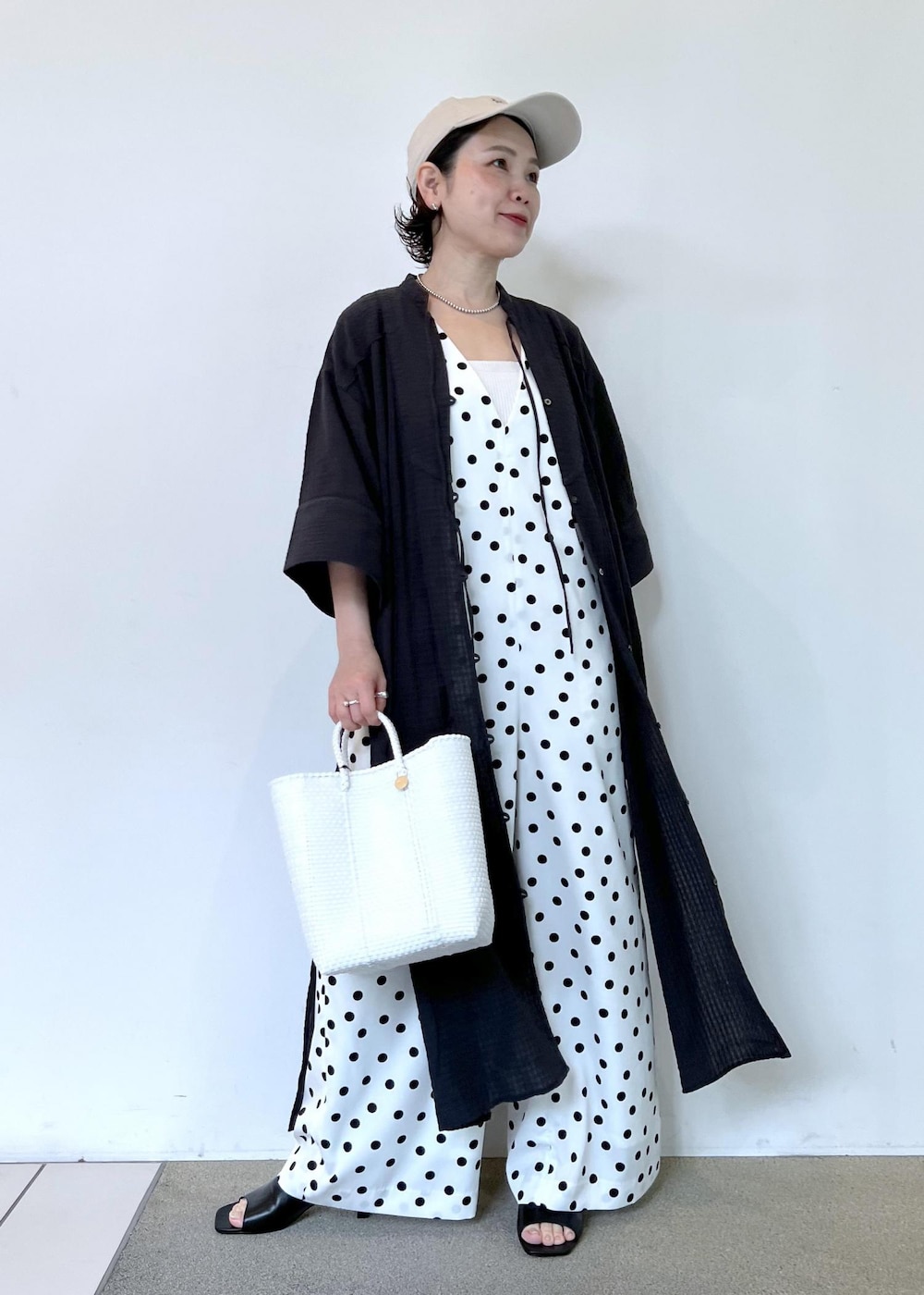 ホワイト系のつなぎ/オールインワン、ホワイト系のかごバッグ、ブラック系のシャツ/ブラウスを着用したレディースの夏コーディネートの4枚目の写真