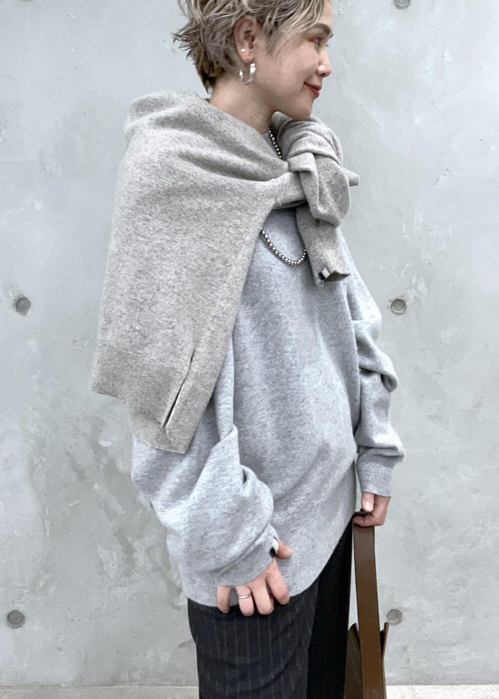 グリーン系のショルダーバッグ、グレー系のスラックス、シルバー系のパンプスを着用したレディースの夏コーディネートの7枚目の写真