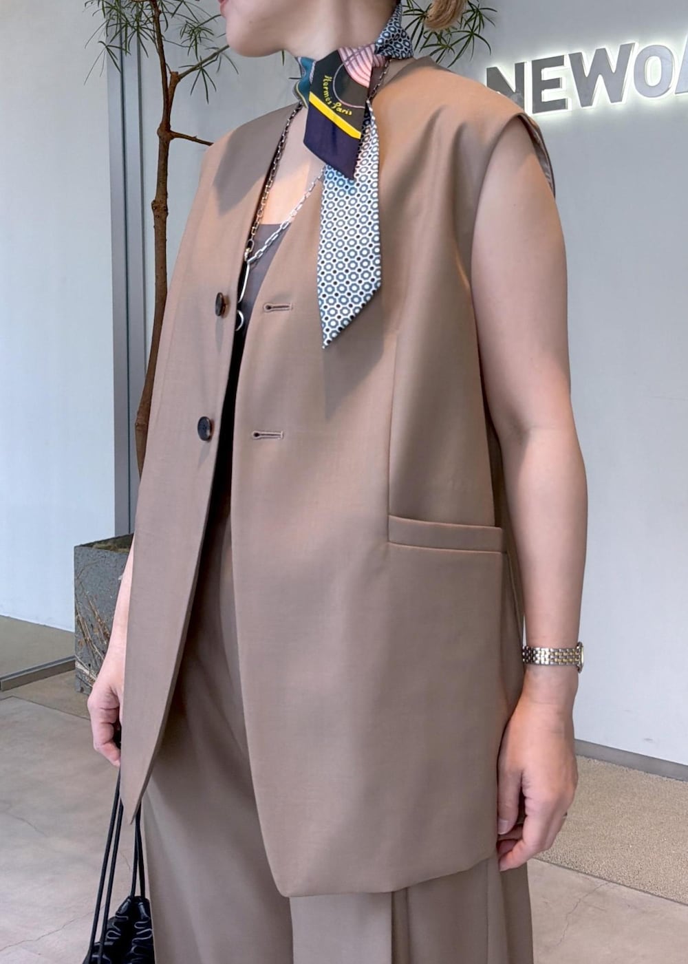 ベージュ系のベスト、ベージュ系のその他パンツ、ブラック系のショルダーバッグを着用したレディースの秋コーディネートの7枚目の写真