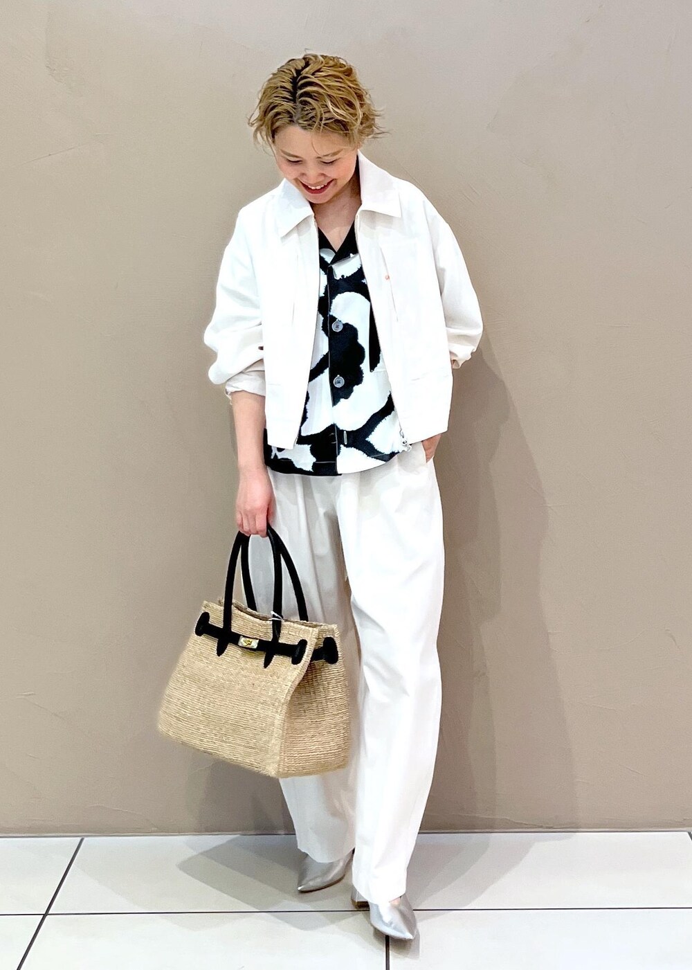 ホワイト系のトートバッグ、ホワイト系のブルゾン、ホワイト系のその他パンツを着用したレディースの春コーディネートの2枚目の写真