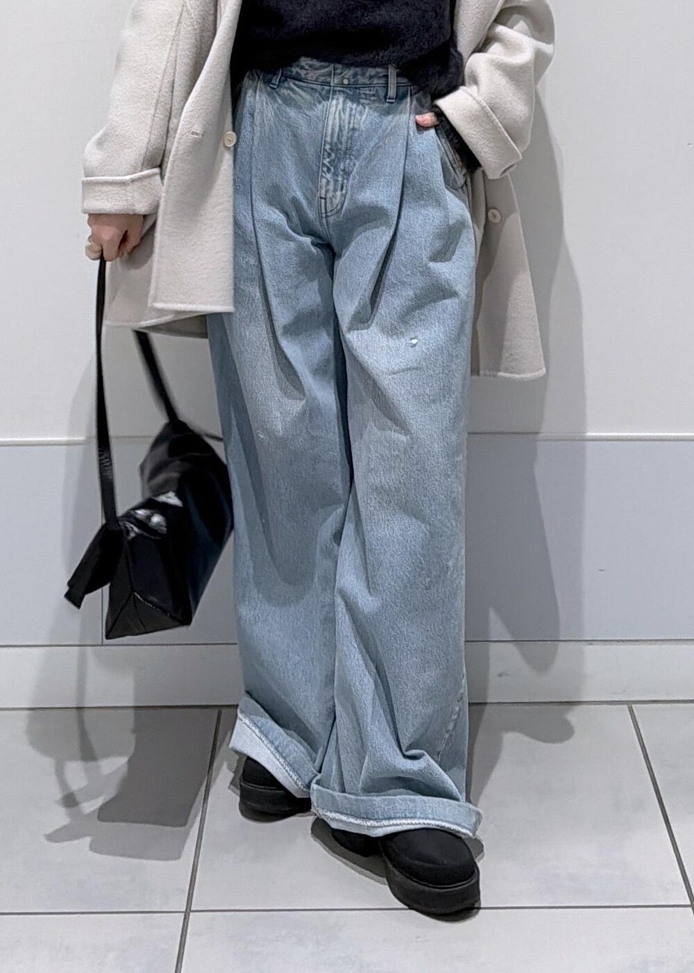 ブラック系のショルダーバッグ、ホワイト系のその他アウター、ブラック系のブーツを着用したレディースの秋コーディネートの7枚目の写真