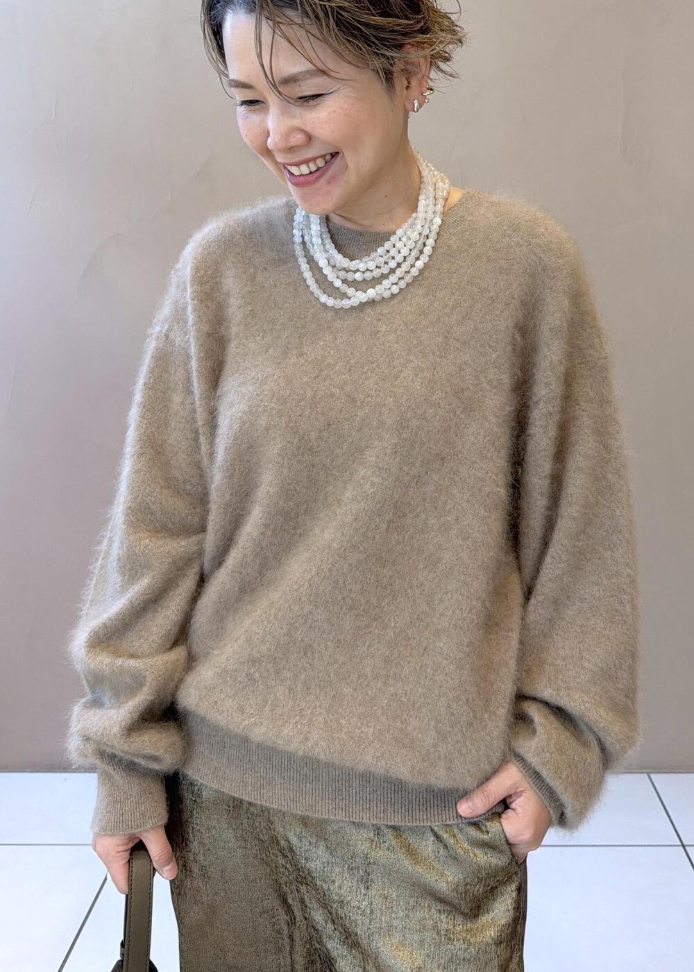 ゴールド系のその他パンツ、ベージュ系のニット/セーター、グリーン系のパンプスを着用したレディースの冬コーディネートの6枚目の写真