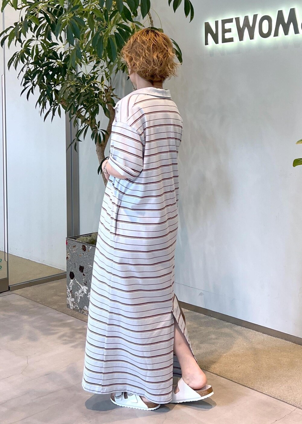 ブラウン系のボストンバッグ、ホワイト系のサンダル、ブルー系のワンピースを着用したレディースの夏コーディネートの4枚目の写真