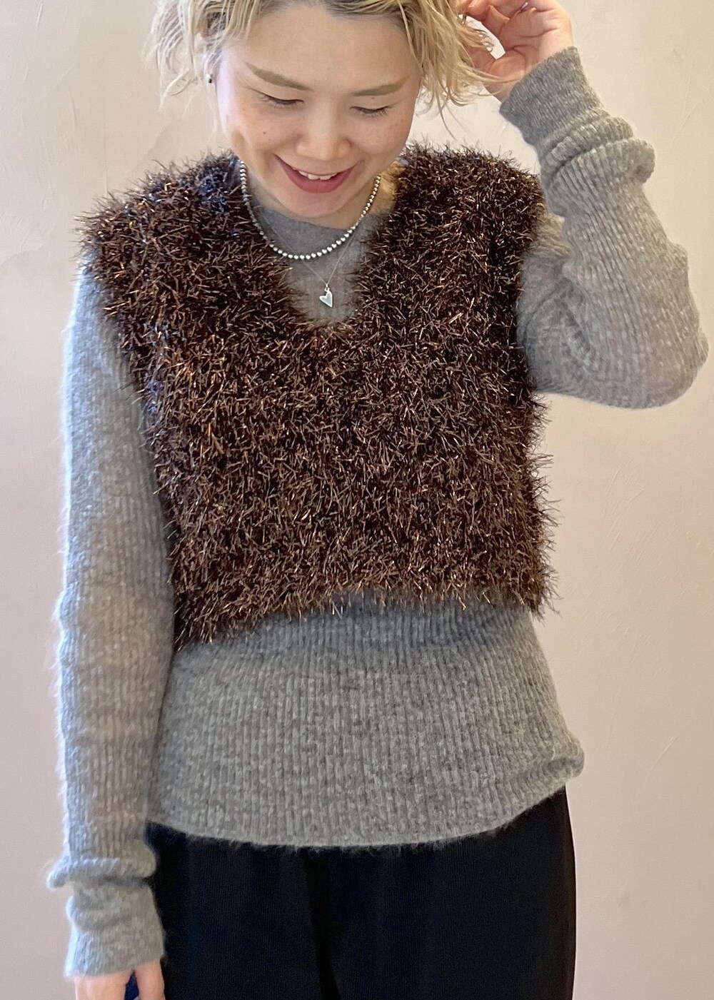 ブラック系のステンカラーコート、グレー系のニット/セーター、ブラック系のその他パンツを着用したレディースの冬コーディネートの7枚目の写真