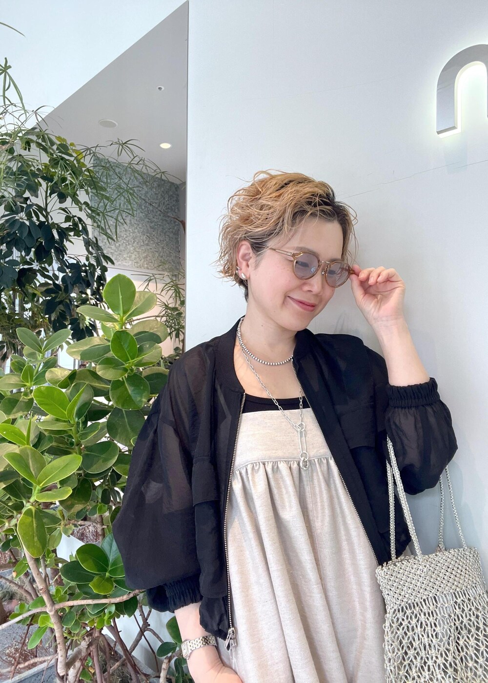 ブラック系のブルゾン、ブラック系のタンクトップ、シルバー系のトートバッグを着用したレディースの春コーディネートの6枚目の写真