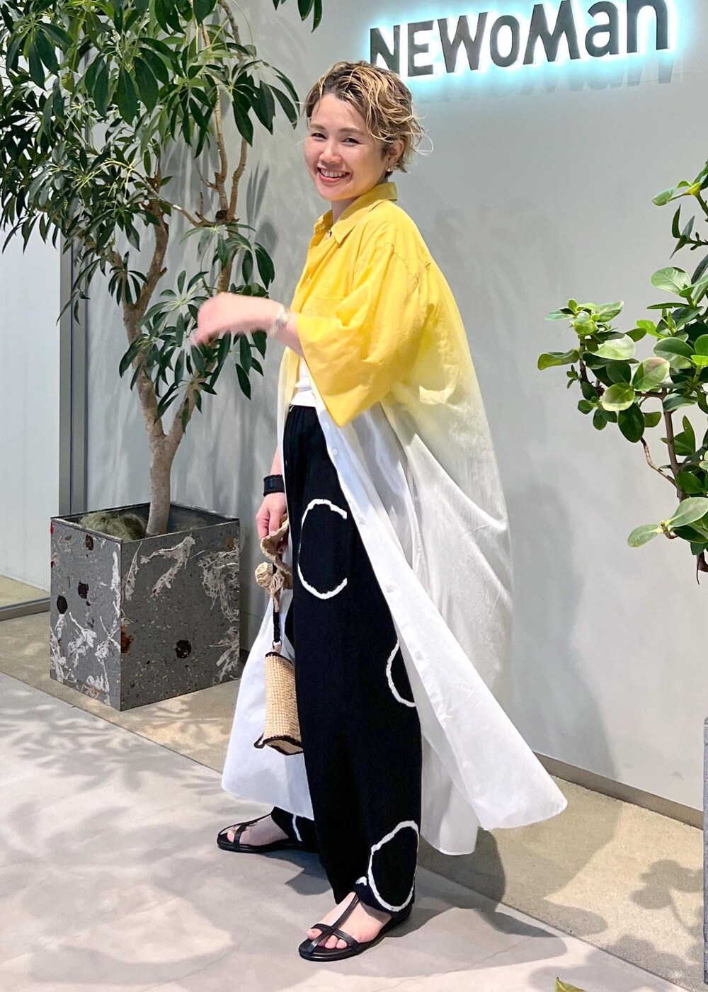 ブラック系のサンダル、ホワイト系のハンドバッグを着用したレディースの夏コーディネートの5枚目の写真