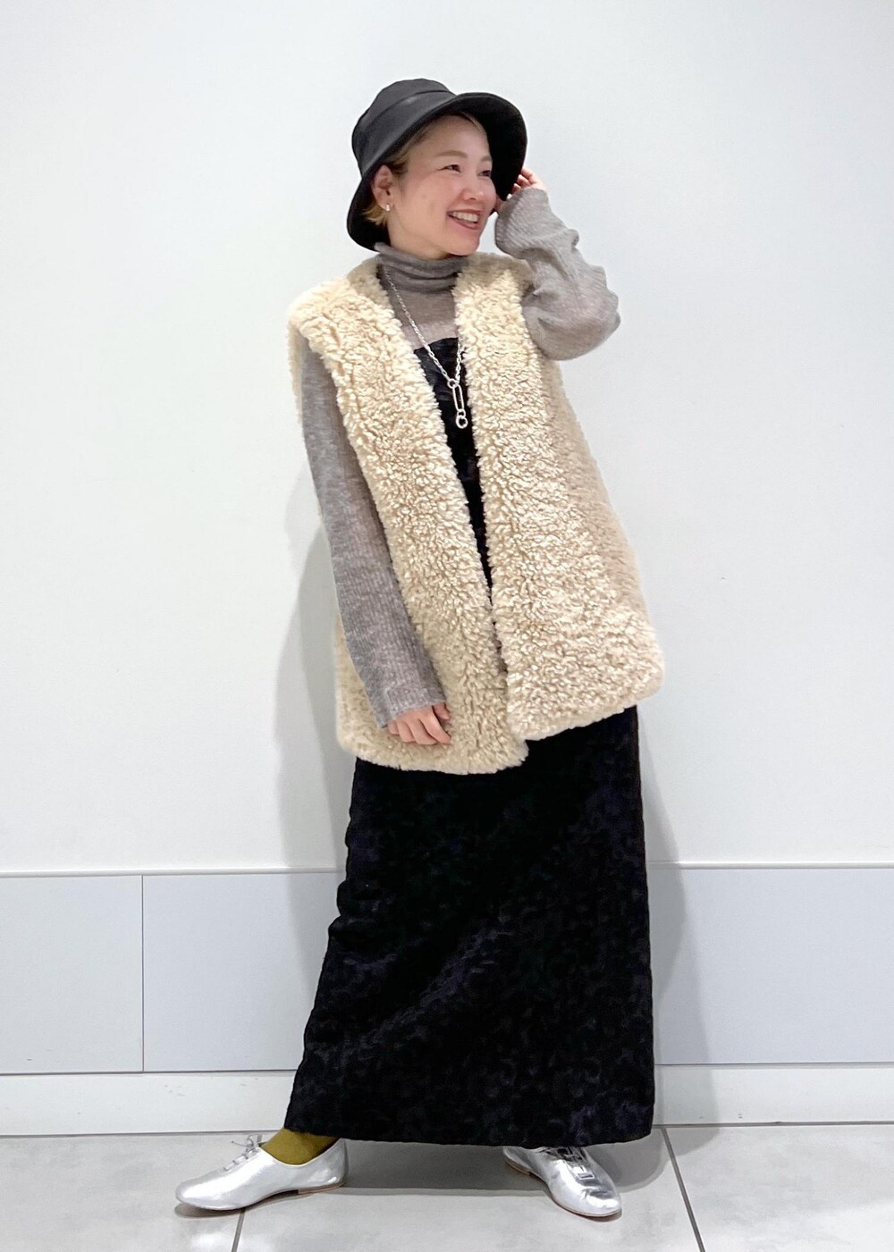 ベージュ系のベスト、ブラック系のワンピース、グレー系のニット/セーターを着用したレディースの秋コーディネートの5枚目の写真