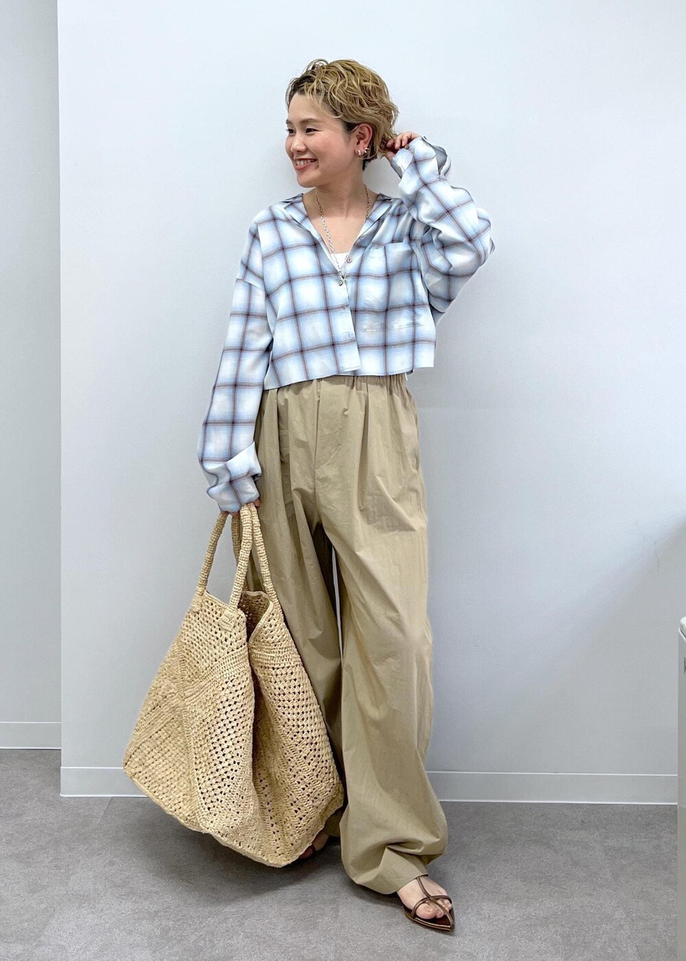 ホワイト系のかごバッグ、その他のサンダル、ベージュ系のその他パンツを着用したレディースの春コーディネートの2枚目の写真